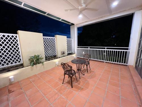 eine Terrasse mit 2 Stühlen und einem Tisch auf dem Balkon in der Unterkunft Botanica Mansion in Balik Pulau