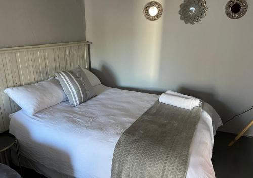 a bed with white sheets and pillows in a room at Stay-A-While by Ustay in Saldanha