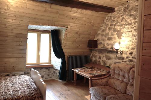 Zimmer mit einem Tisch, einem Sofa und einem Fenster in der Unterkunft La Verte Salamandre in Allanche