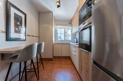a kitchen with a table and chairs and a refrigerator at Oasis Mijas Centro in Mijas