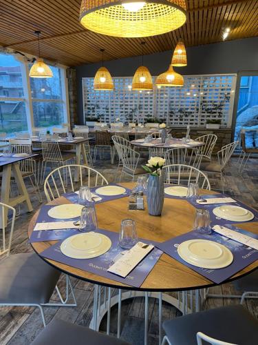 a dining room with tables and chairs and lights at Isalos Suites in Néa Péramos