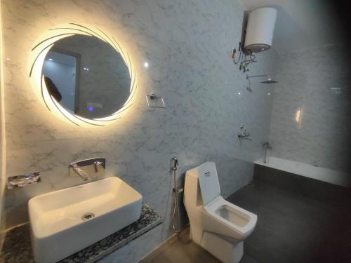 a bathroom with a sink and a toilet and a mirror at RESORT GOLDEN CAVE in Jodhpur