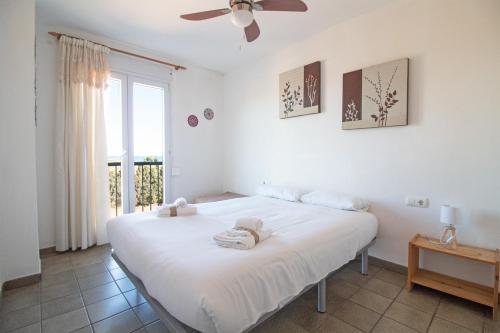 a bedroom with a large white bed with a window at Global Properties, Apartamento con vistas a la playa in Puerto de Sagunto