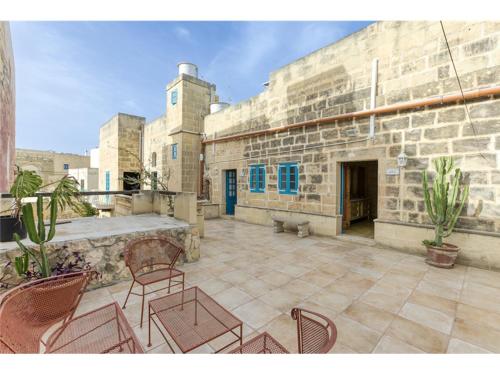un patio avec des chaises et un bâtiment en pierre dans l'établissement Authentic 4 Br Gozitan Farmhouse with Private Pool by 360 Estates, à L-Għarb