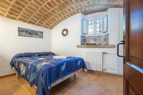 een slaapkamer met een bed met een blauwe deken bij Can Tarana in Santa Cristina d'Aro