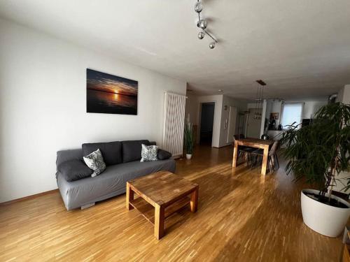 ein Wohnzimmer mit einem Sofa und einem Tisch in der Unterkunft Tobi‘s Ferienapartment in Gottmadingen
