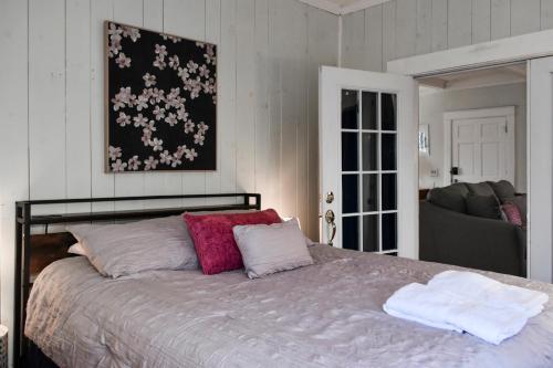 1 dormitorio con 1 cama con almohadas rosas y blancas en In the Heart of Watkins Glen Walk to Parks and Restaurants, en Watkins Glen