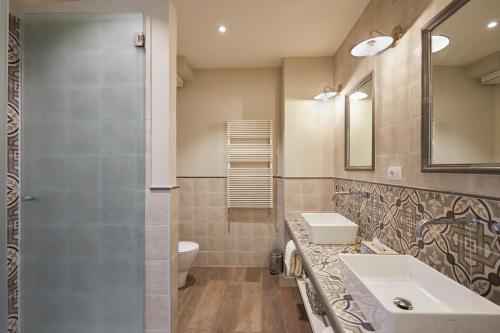 a bathroom with a sink and a toilet and a mirror at Tenuta di Artimino member of Meliá Collection Wine Resort in Artimino