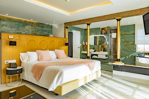 a bedroom with a large bed and a bathroom at Hotel Boutique Cortijo Landete - SOLO ADULTOS in Granada