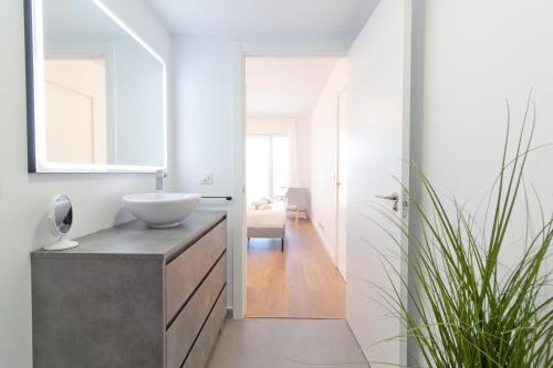 y baño con lavabo y espejo. en Global Properties, Moderno apartamento con piscina y terraza en la playa de Canet, en Canet de Berenguer