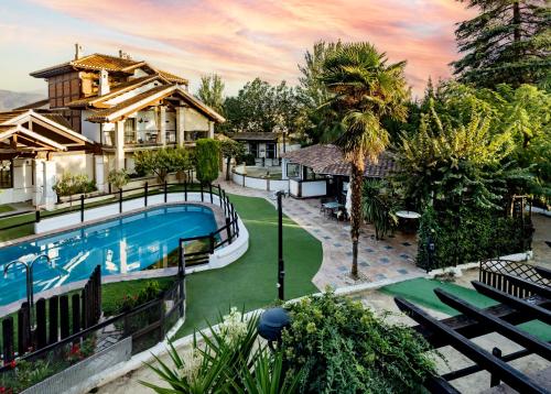 an exterior view of a house with a swimming pool at Hotel Boutique Cortijo Landete - SOLO ADULTOS in Granada