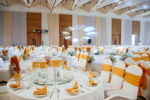 a large banquet hall with white tables and chairs at TTC Van Phong Bay Resort - Himalaya Sauna & Steam Retreat Included in Ninh Hòa