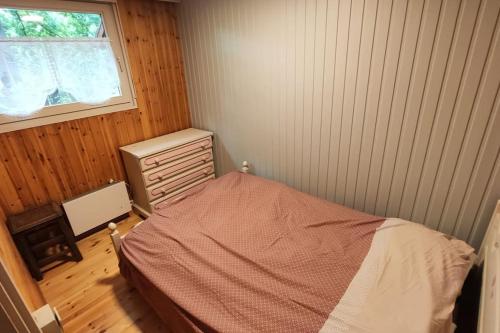 ein kleines Schlafzimmer mit einem Bett und einem Fenster in der Unterkunft Chalet nature au cœur des Ardennes in Somme-Leuze