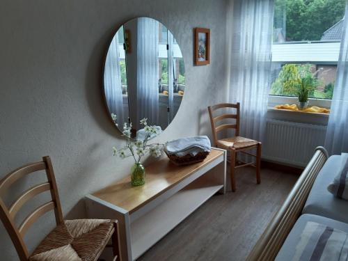 a room with a mirror and a table and chairs at Hortensie, Ferienwohnung in Schneverdingen