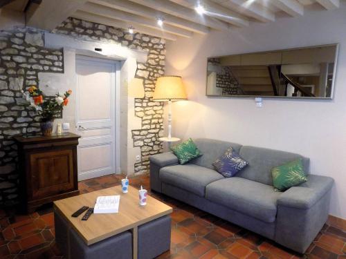 a living room with a couch and a table at Meschers sur Gironde - MAISON mitoyenne EN PIERRES - proximité commerces in Meschers-sur-Gironde