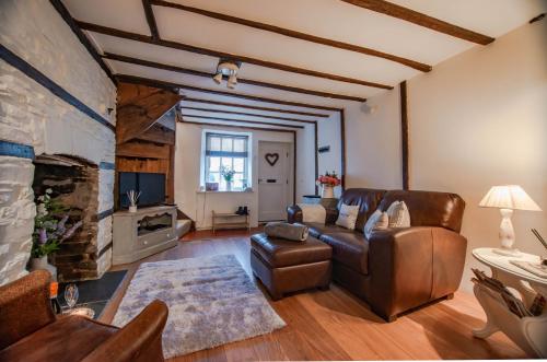 sala de estar con sofá y chimenea en Central Brecon, Pretty Victorian Cottage, en Brecon