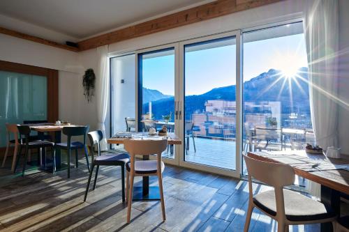 un restaurante con vistas al agua y a las montañas en AGRITUR SEDICI - Bed and Breakfast, en Tenna 