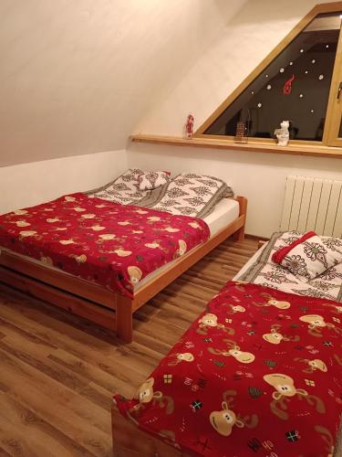 a bedroom with two beds and a window at Domek u Sołtyska in Rajcza