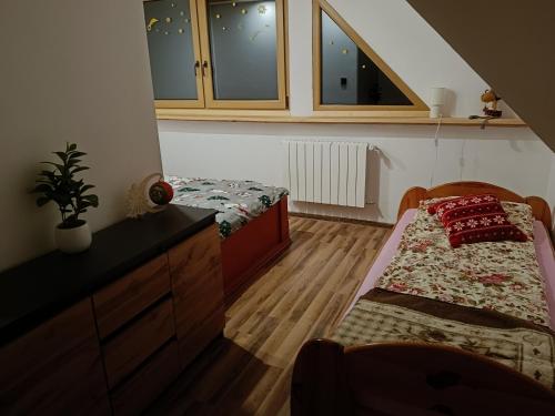 een slaapkamer met 2 bedden, een dressoir en een raam bij Domek u Sołtyska in Rajcza