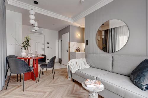 a living room with a couch and a table and a mirror at MameHome Apartments in Krakow