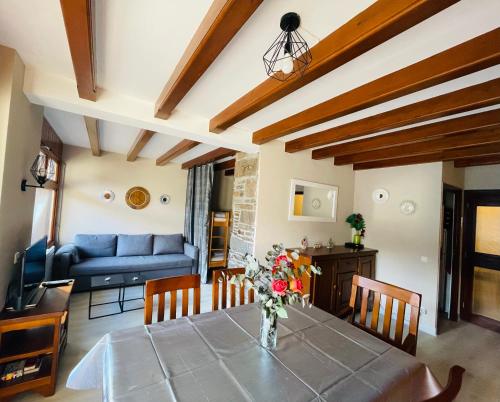 un salon avec une table et un canapé bleu dans l'établissement Appartement 58 m2 avec PISCINE INTÉRIEURE Vue Montagne Centre Village , Parking Privé, à Saint-Lary-Soulan