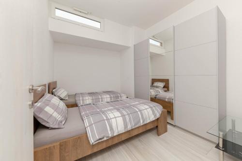 a white bedroom with a bed and a mirror at Apartma Žan in Šmarje