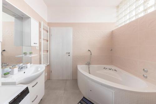 un bagno bianco con vasca e lavandino di Apartma Žan a Šmarje
