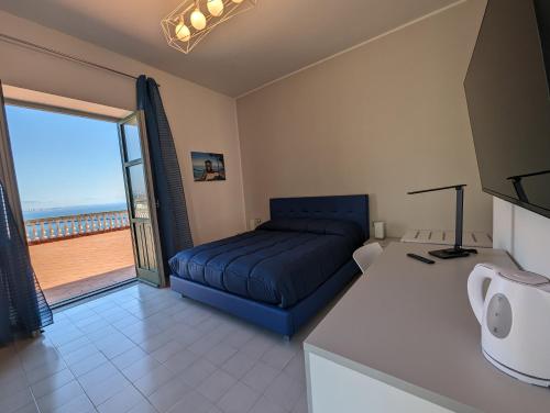 a bedroom with a blue bed and a balcony at Villa Carosino in Vietri sul Mare