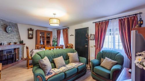 sala de estar con sofá verde y chimenea en Villa Muñoz Ronda by Ruralidays en Ronda