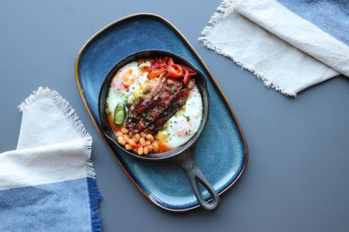 a bowl of food on a blue plate with a spoon at VISIONAPARTMENTS Bucharest - contactless check-in in Bucharest