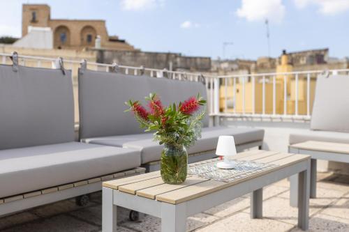 a vase with flowers sitting on a table on a roof at La Loggetta in Ugento