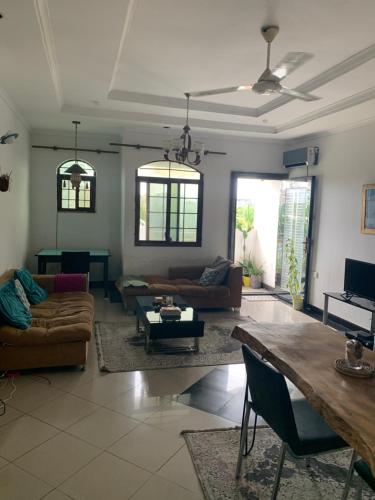 een woonkamer met banken en een tafel bij Good Vibes Stay in Dar es Salaam