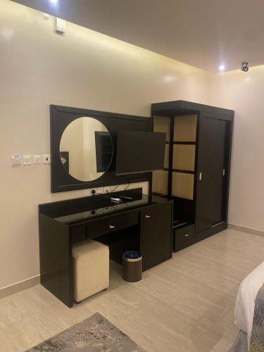 a bedroom with a tv and a mirror on the wall at رفان للشقق المخدومة in Khamis Mushayt