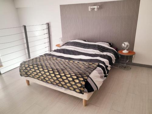Schlafzimmer mit einem Bett mit einem Kopfteil aus Metall in der Unterkunft L'Erissy D'Acqs in Dax
