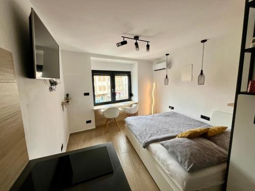 - une chambre avec un lit, un bureau et une fenêtre dans l'établissement Apartmani Audacia Crikvenica, à Crikvenica