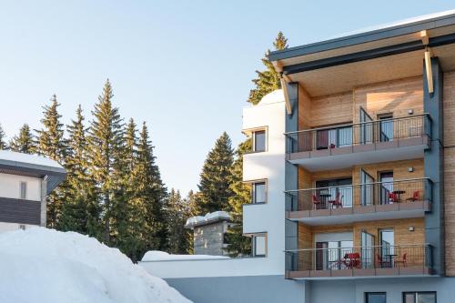 a apartment building with a balcony in the snow at Belambra Clubs Les Saisies - Les Embrunes - Ski pass included in Villard-sur-Doron