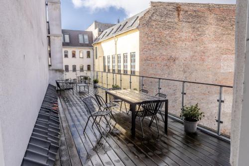 a balcony with a table and chairs on a building at Penthouse w/rooftop terrace in latin quarter in Copenhagen