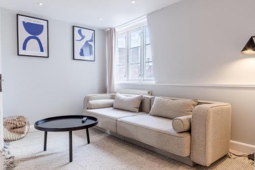 a living room with a couch and a table at Penthouse w/rooftop terrace in latin quarter in Copenhagen