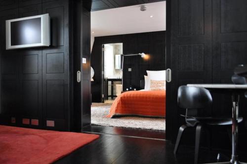 a bedroom with a bed and a table and a television at Myhotel Bloomsbury in London