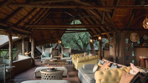 a large living room with couches and a table at Mashatu Lodge in Lentswelemoriti