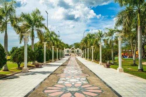 a walkway lined with palm trees in a park at The CentrePoint Hotel in Kampong Gadong