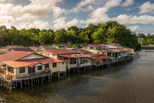 a group of houses on a dock on the water at The CentrePoint Hotel in Bandar Seri Begawan