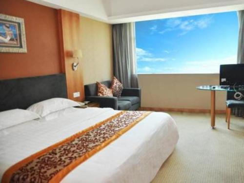 um quarto de hotel com uma cama grande e uma janela grande em Chang An Hotel em Shenzhen