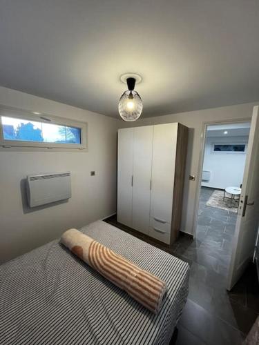 een slaapkamer met een bed met een kussen erop bij Élégante Maison d'Hôte Neuve in Villeneuve-le-Roi