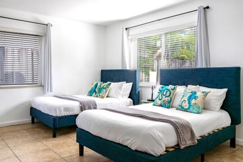 twee blauwe bedden in een kamer met ramen bij Hollywood Broadwalk Holiday Retreat 5 walk Beach in Dania Beach