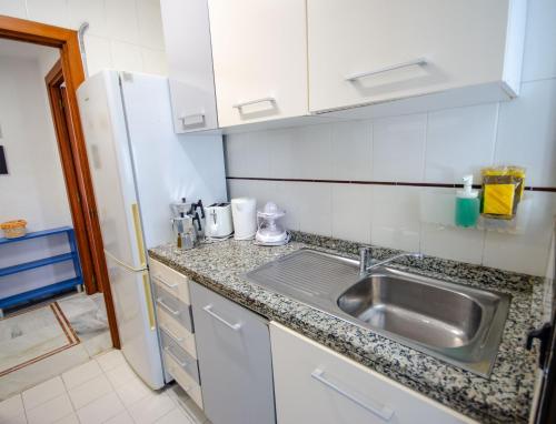 a kitchen with a sink and a refrigerator at SOL 7 Levante Beach in Benidorm