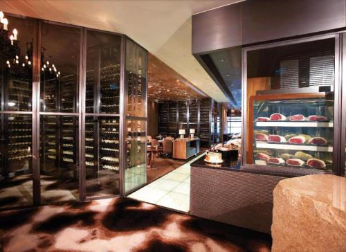 ein Restaurant mit einem Weinkeller mit Weinflaschen in der Unterkunft Grand Lisboa Hotel in Macau
