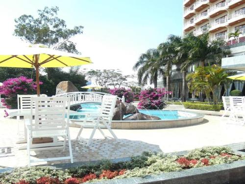 波來古的住宿－HAGL Hotel Gia Lai，喷泉旁的一组椅子和一把伞