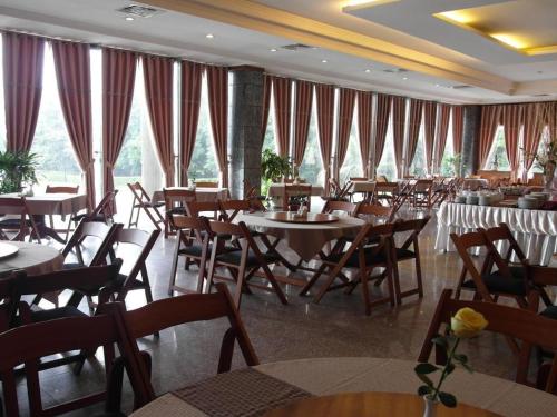 jadalnia ze stołami, krzesłami i oknami w obiekcie HAGL Hotel Gia Lai w mieście Pleiku
