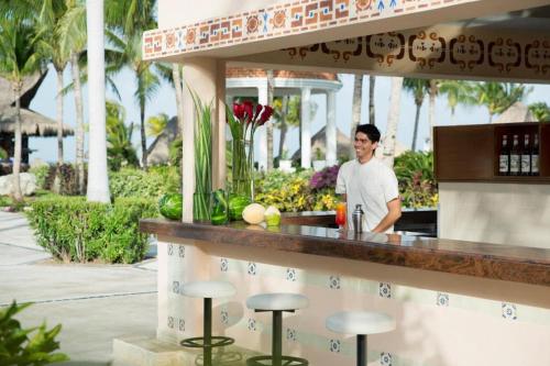Ein Mann steht in einer Bar in einem Resort. in der Unterkunft Excellence Riviera Cancun All Inclusive - Adults Only in Puerto Morelos